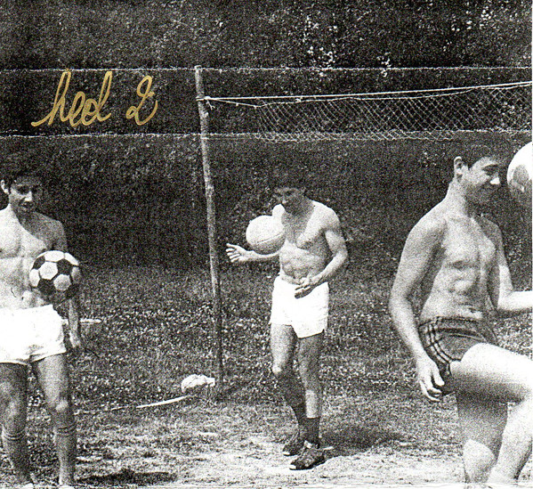 Cover of Heol Daou. Black and white photo of several shirtless young men juggling footballs. On the top left corner, the words 'Heol 2'.